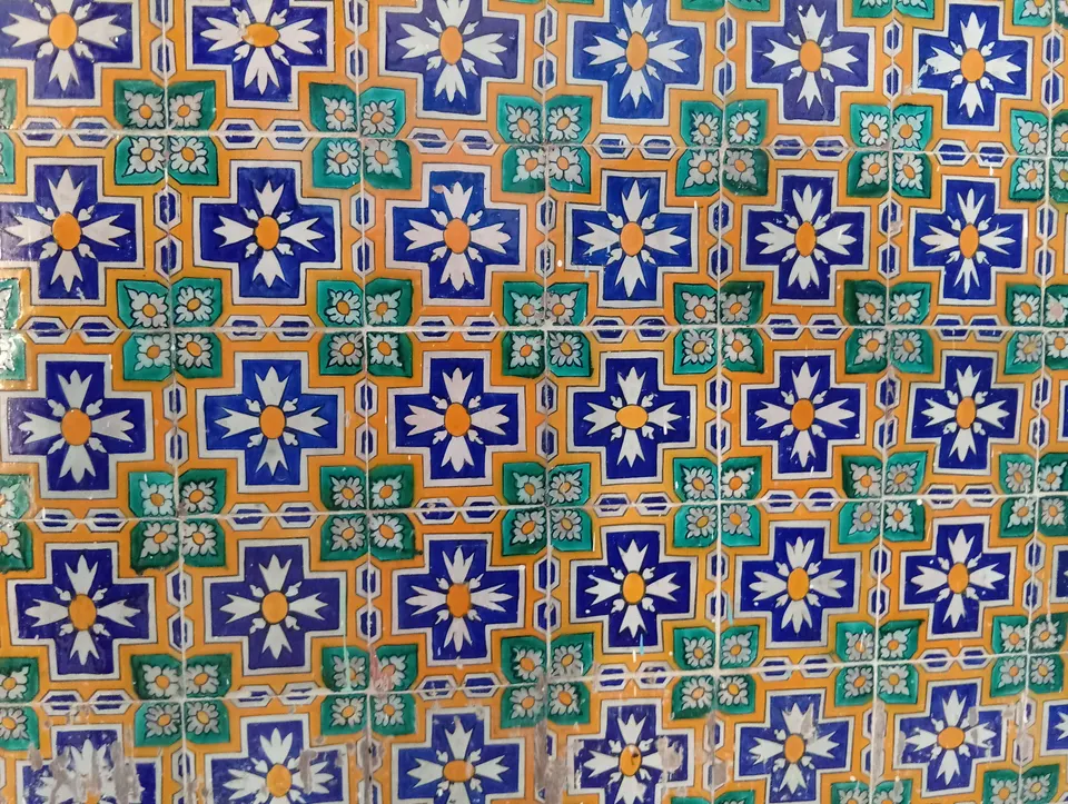 Ceramic tiles with a blue, green and orange pattern on an interior wall